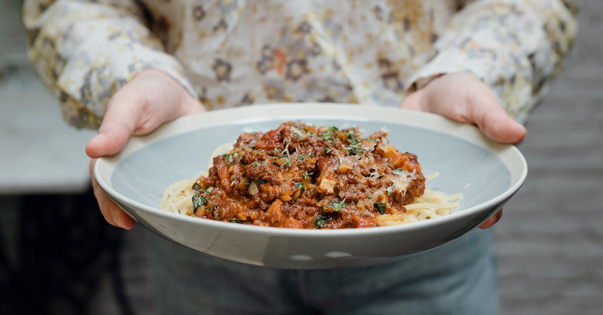 secret ingredient in a restaurant bolognese - Crop faceless young waitress in casual clothes offering plate of appetizing spaghetti bolognese in bowl secret ingredient in a restaurant bolognese - Crop faceless young waitress in casual clothes offering plate of appetizing spaghetti bolognese in bowl
