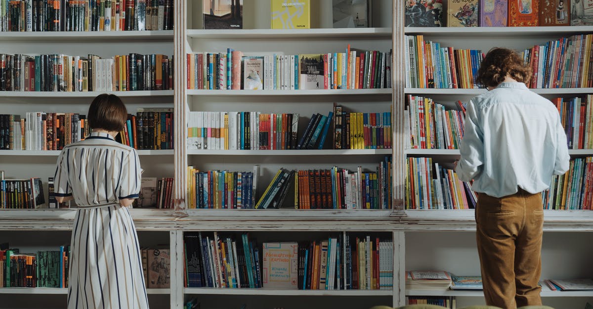 Selecting [corn] for Pozole? - Man in White Dress Shirt Standing Beside Brown Wooden Book Shelf