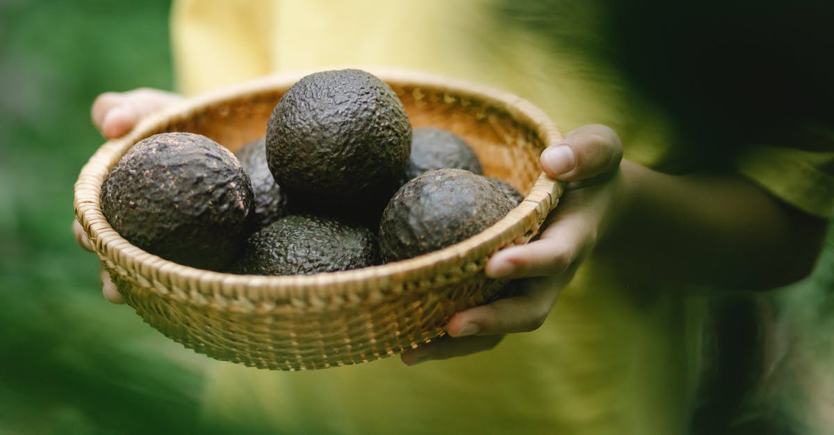 semi-freezing ripe avocado for easier handling - Crop faceless female holding wicker bowl full of avocado while standing in garden semi-freezing ripe avocado for easier handling - Crop faceless female holding wicker bowl full of avocado while standing in garden