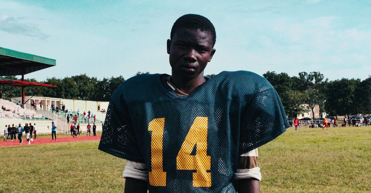 Serious buildup outside of cast iron skillet - Black player of American football on stadium Serious buildup outside of cast iron skillet - Black player of American football on stadium