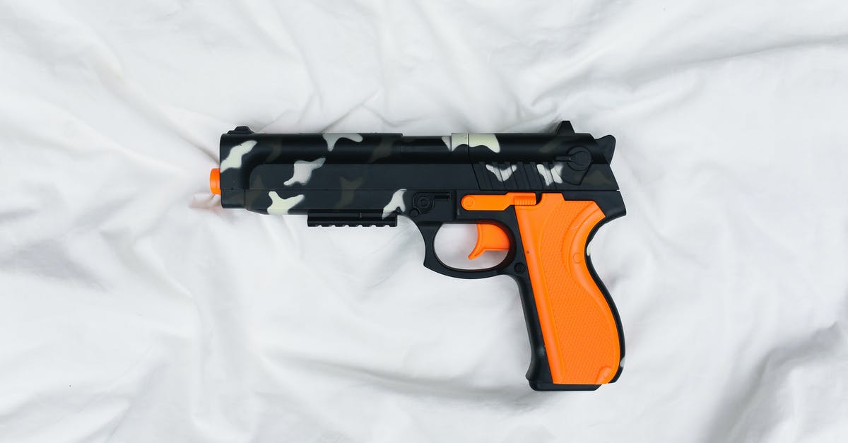 Shallow frying safety - Black and Orange Semi Automatic Pistol on White Textile Shallow frying safety - Black and Orange Semi Automatic Pistol on White Textile