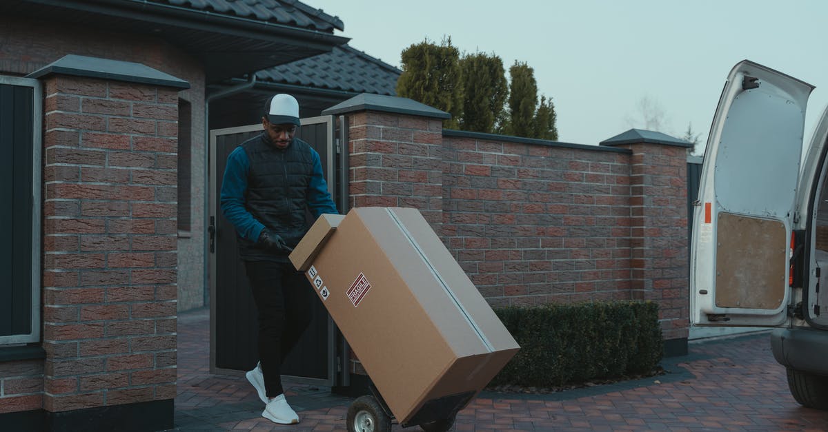 shipping cheese - Man in Blue Jacket and Blue Denim Jeans Standing Beside Brown Cardboard Box shipping cheese - Man in Blue Jacket and Blue Denim Jeans Standing Beside Brown Cardboard Box