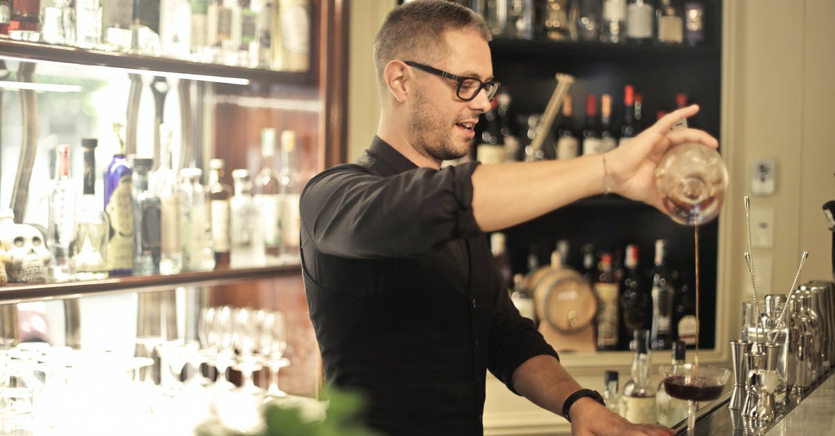 Should boiled legumes cool before processing? - Side view of positive young barman in black uniform and eyeglasses pouring wine into glass while working at bar counter in modern restaurant Should boiled legumes cool before processing? - Side view of positive young barman in black uniform and eyeglasses pouring wine into glass while working at bar counter in modern restaurant
