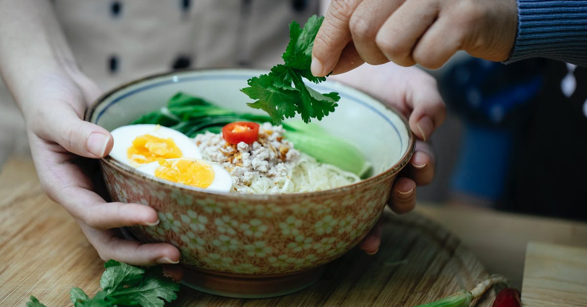 Should I add broth to the bottom of the Dutch Oven? - Crop unrecognizable women decorating Asian noodle soup with parsley Should I add broth to the bottom of the Dutch Oven? - Crop unrecognizable women decorating Asian noodle soup with parsley