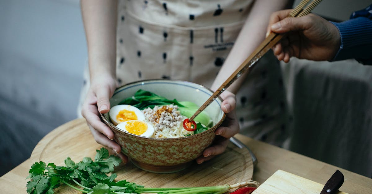 Should I add broth to the bottom of the Dutch Oven? - Crop unrecognizable women decorating noodles soup with cut chili pepper Should I add broth to the bottom of the Dutch Oven? - Crop unrecognizable women decorating noodles soup with cut chili pepper