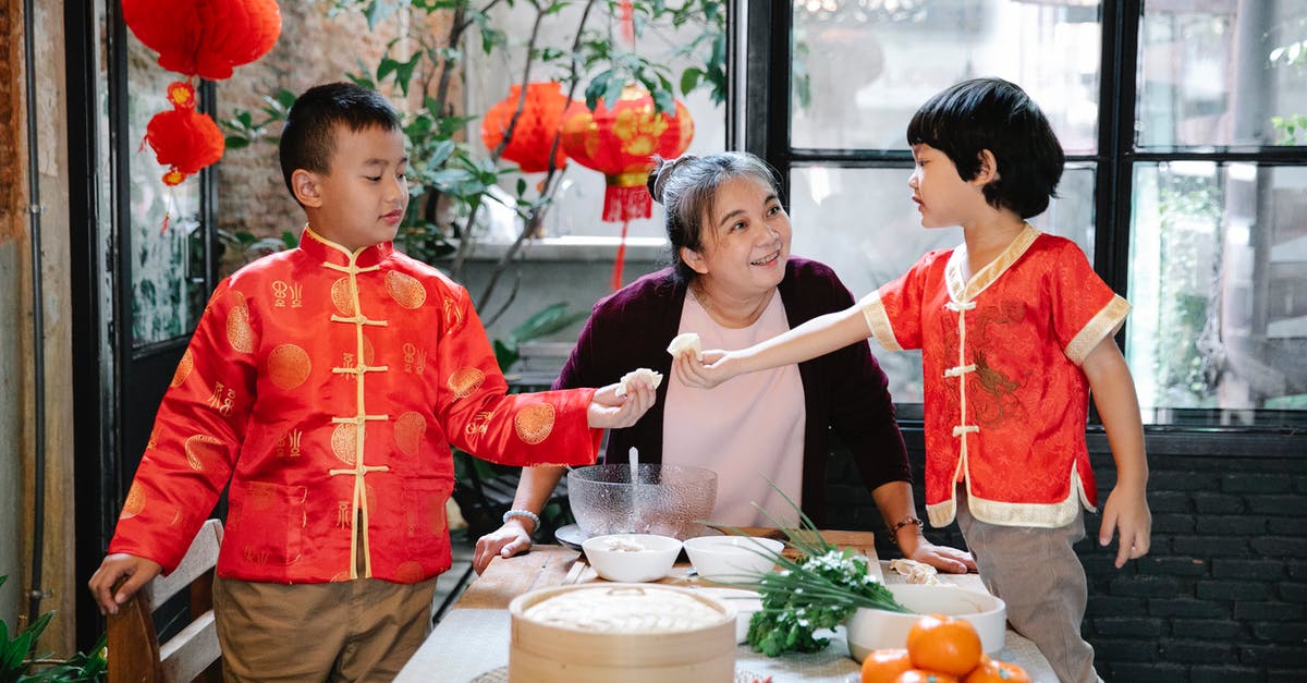 Should I freeze gyoza before or after cooking? - Asian grandmother cooking dumplings with grandsons Should I freeze gyoza before or after cooking? - Asian grandmother cooking dumplings with grandsons