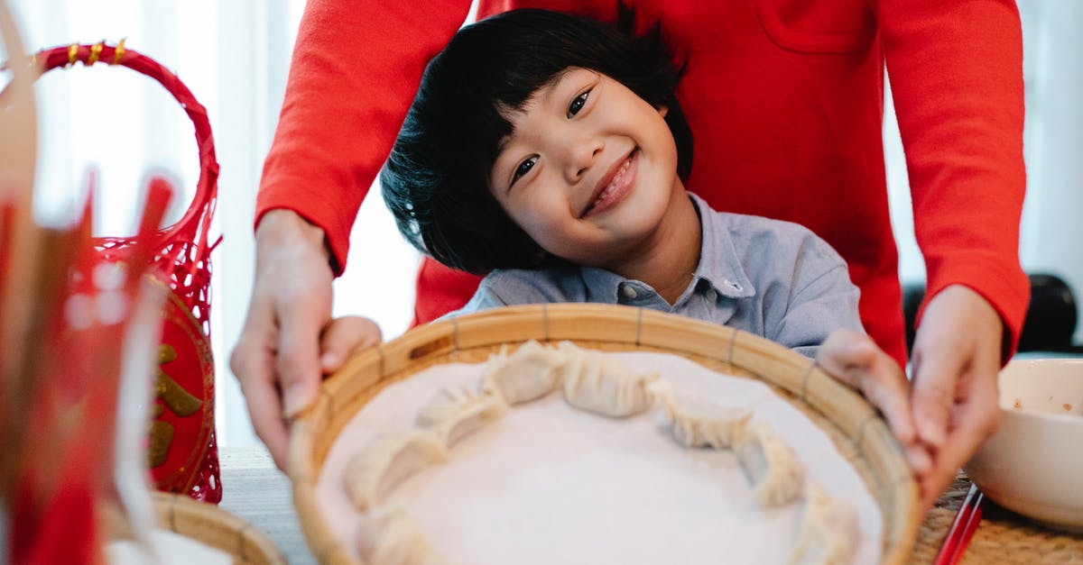 Should I freeze gyoza before or after cooking? - Smiling Asian boy showing handmade dumplings Should I freeze gyoza before or after cooking? - Smiling Asian boy showing handmade dumplings