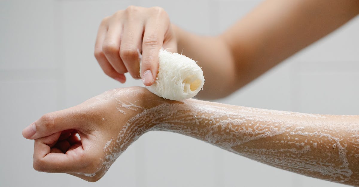 Should I remove the foam when cooking chickpeas? - Crop anonymous person using wisp washing arms with soap foam during hygienic procedure