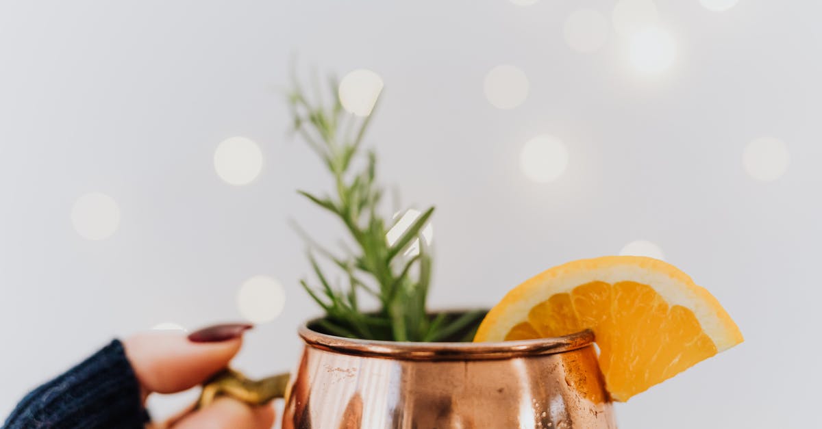 Should I season my paellera? - Person Holding Clear Glass Mug With Orange Juice