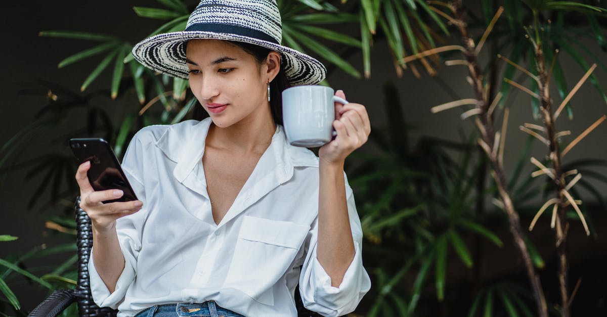 Should I use dried or fresh chilli/ginger in chai tea? - Young Asian lady wearing stylish outfit sitting in wicker armchair in greenery and browsing smartphone while drinking hot beverage Should I use dried or fresh chilli/ginger in chai tea? - Young Asian lady wearing stylish outfit sitting in wicker armchair in greenery and browsing smartphone while drinking hot beverage