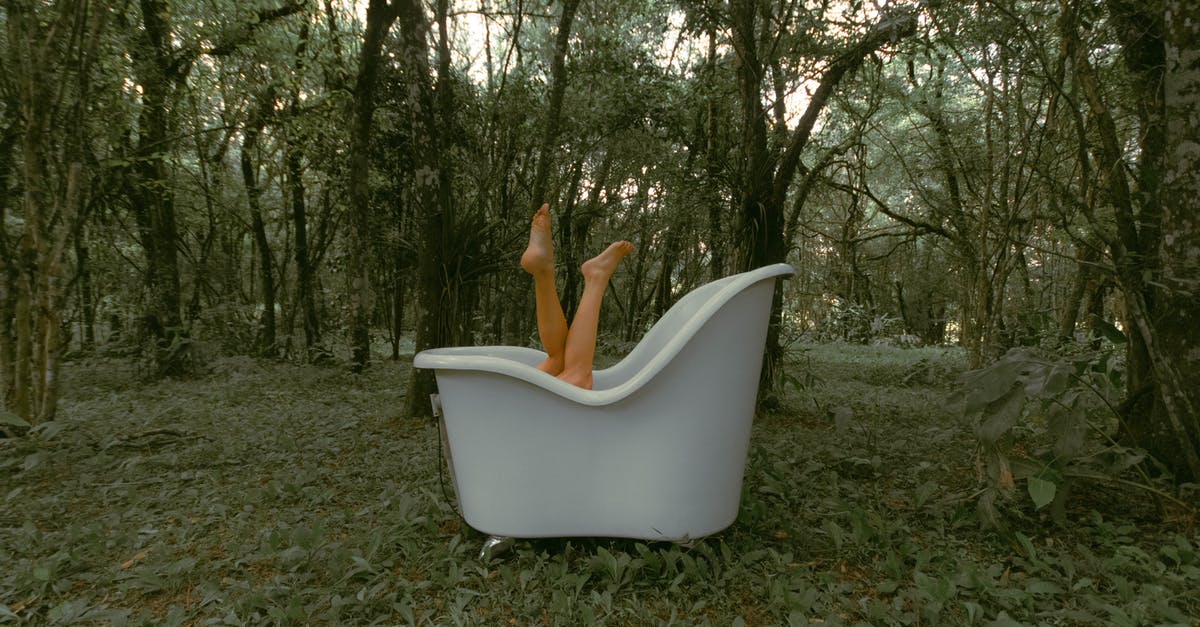 Should I wash my pre-washed greens? - Unrecognizable female lying in bathtub with legs raised on grassy terrain near tall lush trees in woodland during daily routine Should I wash my pre-washed greens? - Unrecognizable female lying in bathtub with legs raised on grassy terrain near tall lush trees in woodland during daily routine