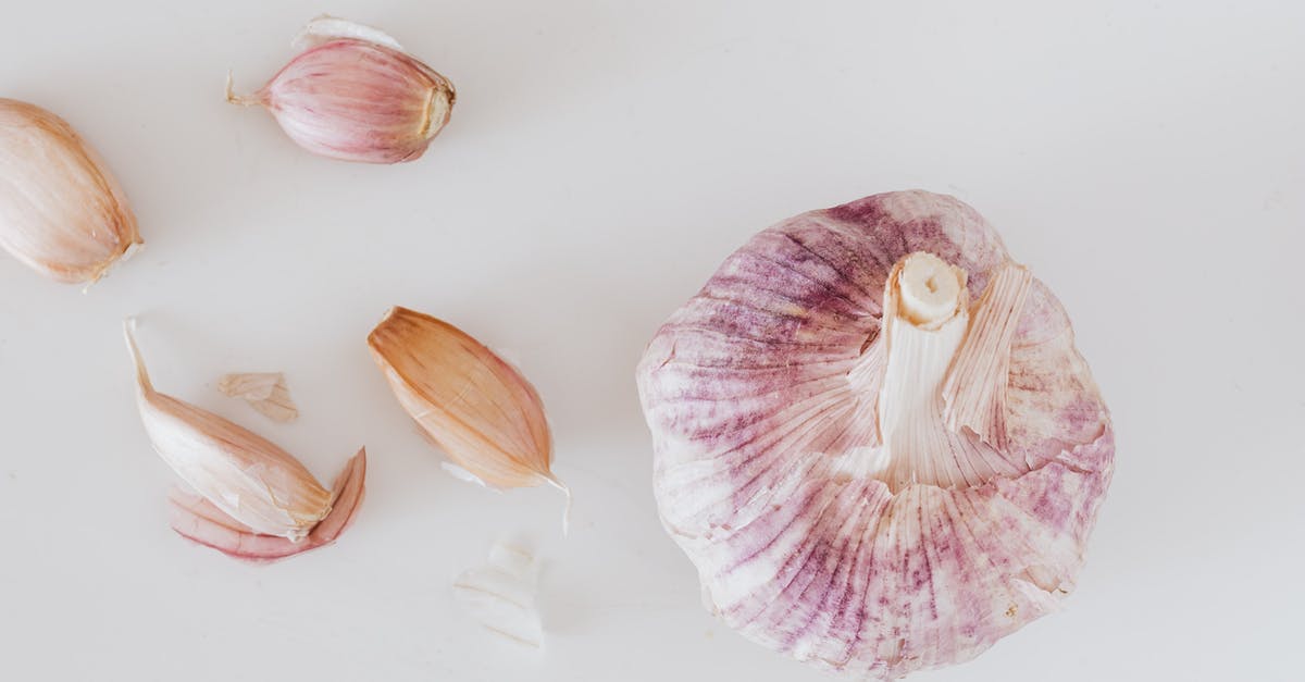 Should one always use the whole garlic clove? - From above closeup of big whole garlic and set of cloves placed on white surface