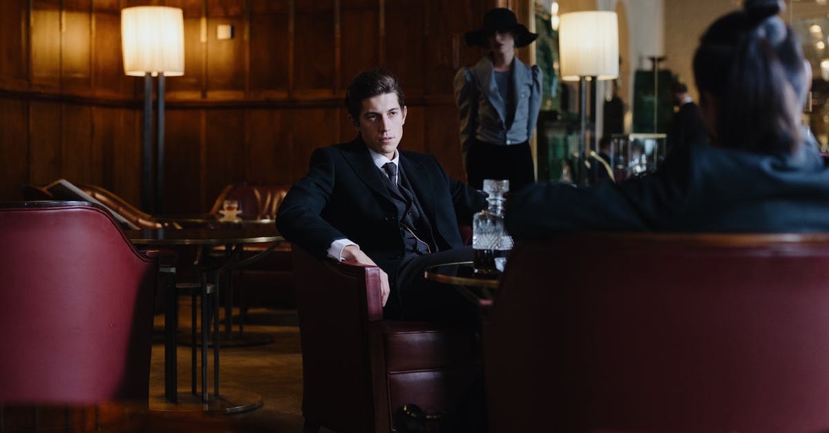 Silverfish in a restaurant - Man in Black Suit Sitting on Black Leather Chair Silverfish in a restaurant - Man in Black Suit Sitting on Black Leather Chair