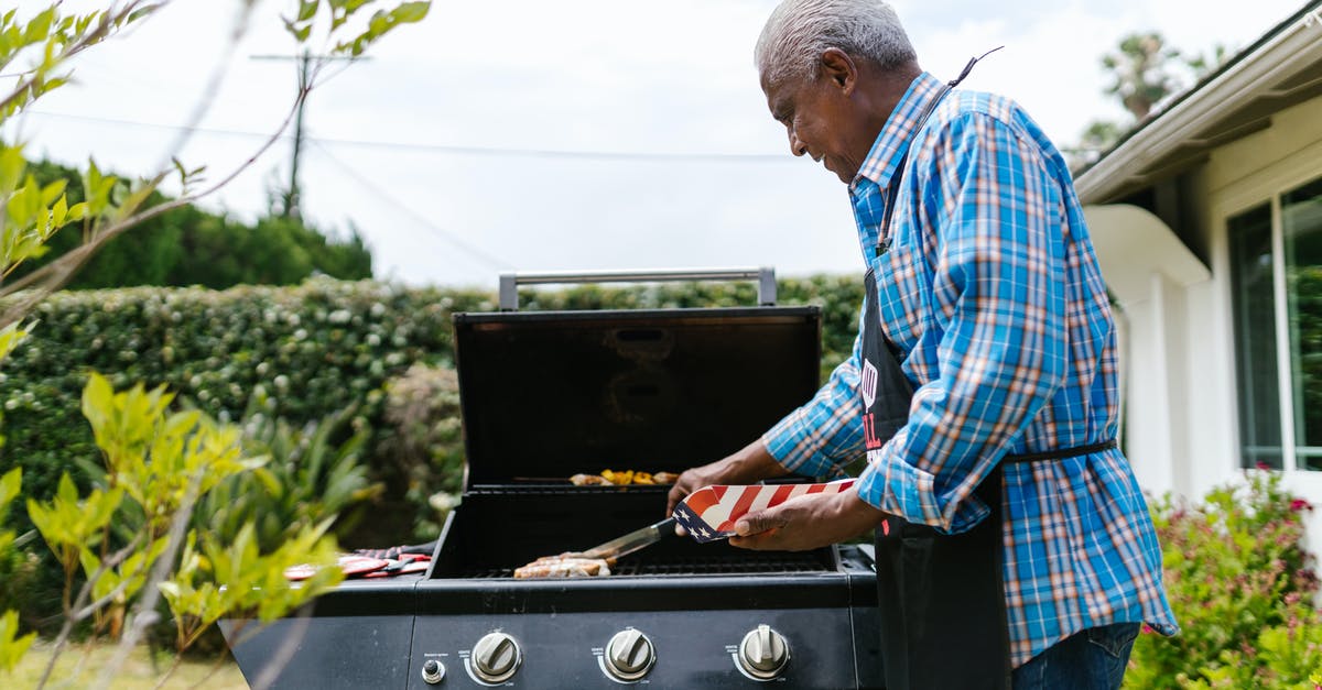 Slicing bratwurst for quicker, more even grilling - Elderly Man Putting Hotdogs on a Griller Slicing bratwurst for quicker, more even grilling - Elderly Man Putting Hotdogs on a Griller