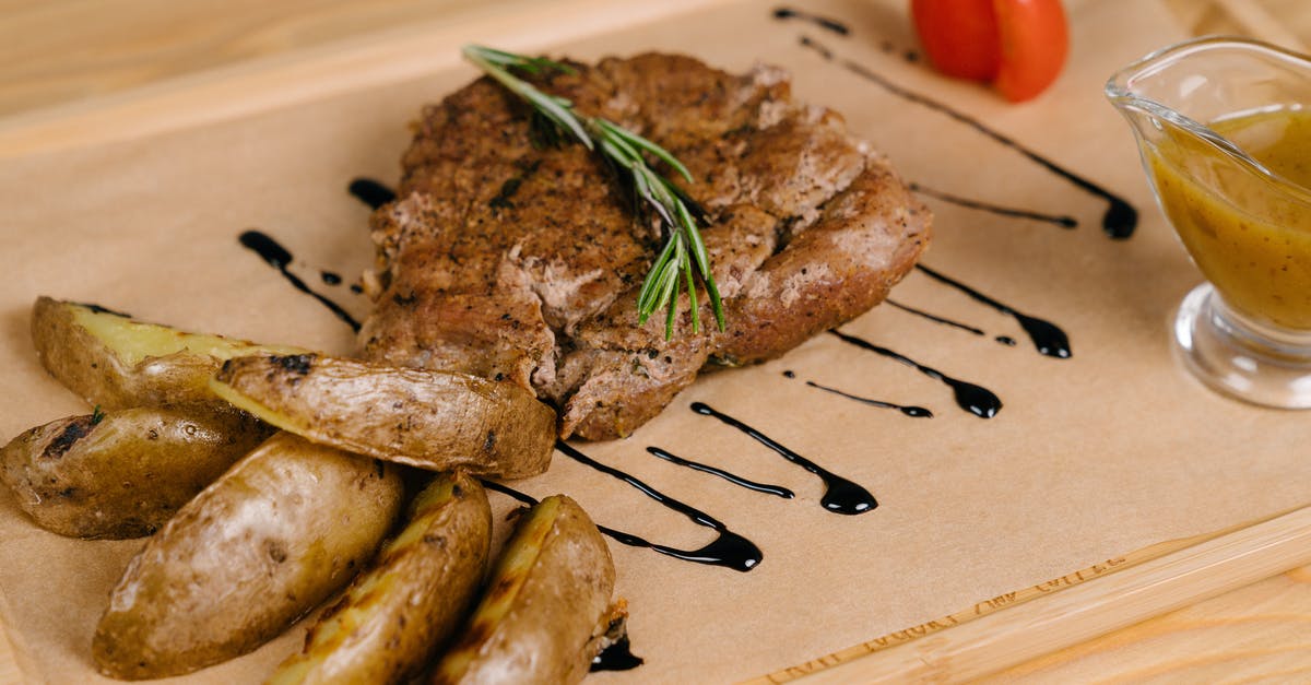 Slow roasting potatoes - Roasted Meat and Potatoes on Brown Wooden Board Slow roasting potatoes - Roasted Meat and Potatoes on Brown Wooden Board