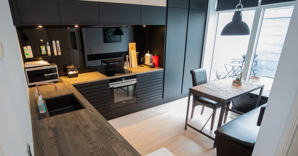 Small Black Screw left inside microwave oven [closed] - Stylish kitchen with wooden table