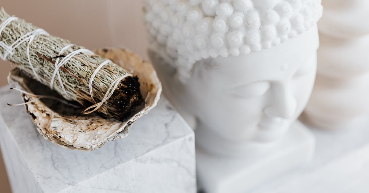 Smoking dried peppers? - From above of sage candle in bowl placed on white marble shelf near plaster Buddha bust and creative shape vase for home decoration Smoking dried peppers? - From above of sage candle in bowl placed on white marble shelf near plaster Buddha bust and creative shape vase for home decoration