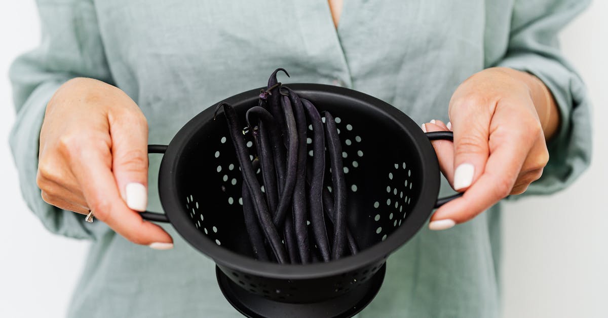 Soaking legumes and cooking another day - Person Holding Black Round Colander Soaking legumes and cooking another day - Person Holding Black Round Colander