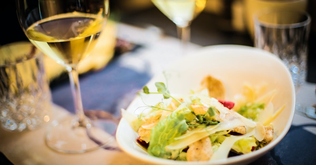 Soft dinner rolls always taste bland or flat - High angle of tasty salad made of fresh vegetables and green herbs placed on table with glass of wine in luxury restaurant