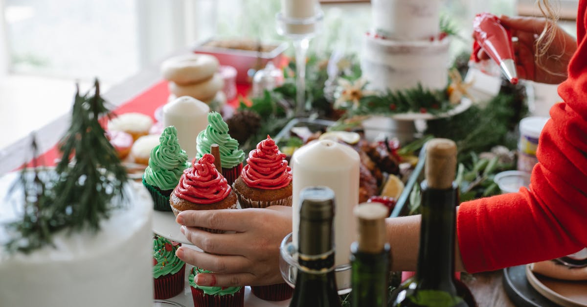 Soften fats for buttercream - Crop anonymous female chef with buttercream in pastry bag and yummy cupcakes at table with decor on Christmas day Soften fats for buttercream - Crop anonymous female chef with buttercream in pastry bag and yummy cupcakes at table with decor on Christmas day
