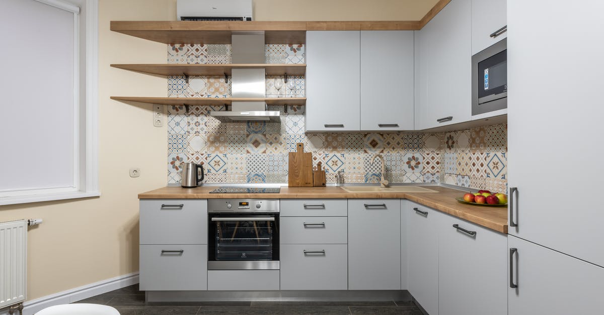 Solution for uneven heating on an electric coil stovetop - Modern kitchen with cabinets and electric stove with oven under hood illuminated by shiny lamp in house Solution for uneven heating on an electric coil stovetop - Modern kitchen with cabinets and electric stove with oven under hood illuminated by shiny lamp in house
