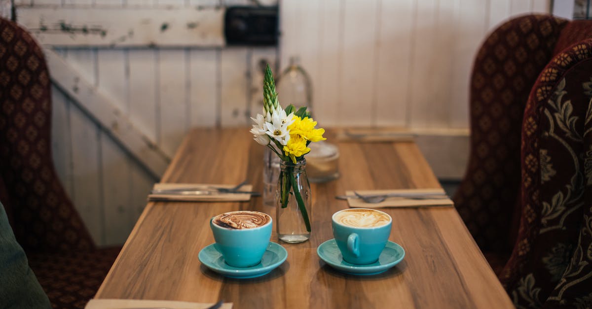 Soup has a floral taste - Cups of cappuccino served on table in cafeteria Soup has a floral taste - Cups of cappuccino served on table in cafeteria