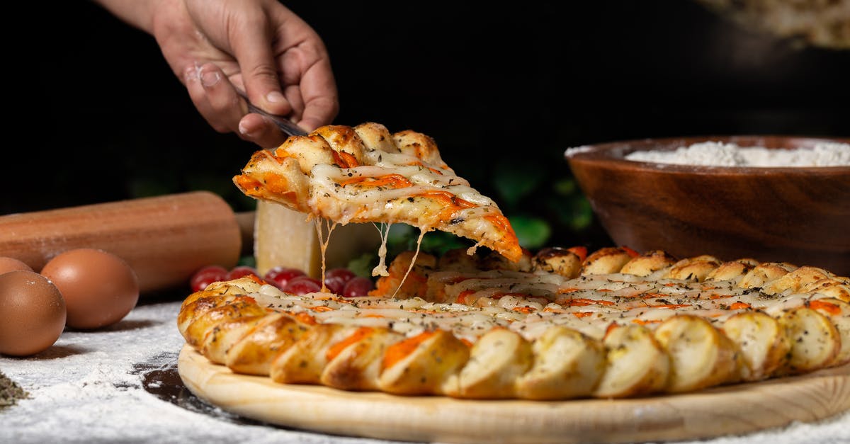 Sourdough pizza crust for wood-fired oven - Person Holding Pizza on Wooden board Sourdough pizza crust for wood-fired oven - Person Holding Pizza on Wooden board