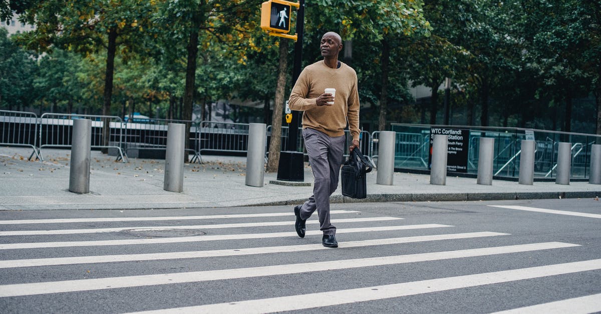 Sourdough teacakes/hot cross buns? - Full body of African American male walking on pedestrian crossing on asphalt road with cup of hot drink and briefcase Sourdough teacakes/hot cross buns? - Full body of African American male walking on pedestrian crossing on asphalt road with cup of hot drink and briefcase