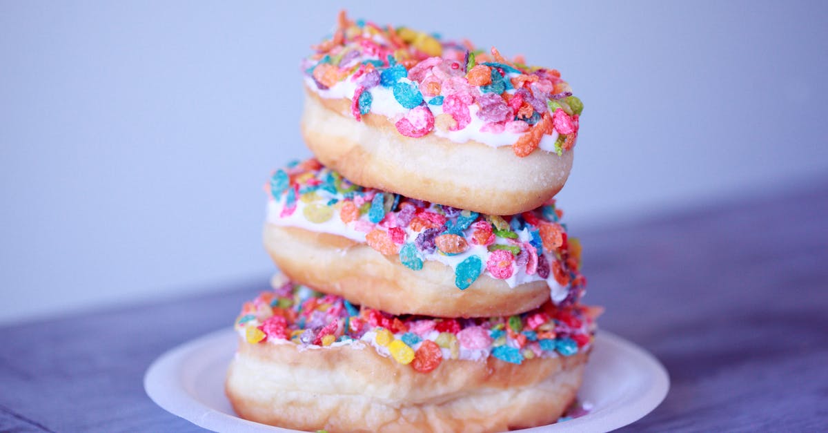 Sprinkles on rolled icing - Close-up Photo of Stacked of Doughnuts Sprinkles on rolled icing - Close-up Photo of Stacked of Doughnuts