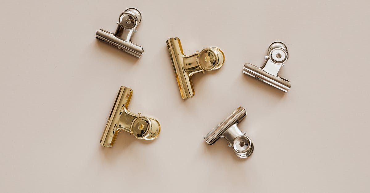 Stainless Steel Pan -- gray bottom. Why? - Set of metal clips on beige background Stainless Steel Pan -- gray bottom. Why? - Set of metal clips on beige background
