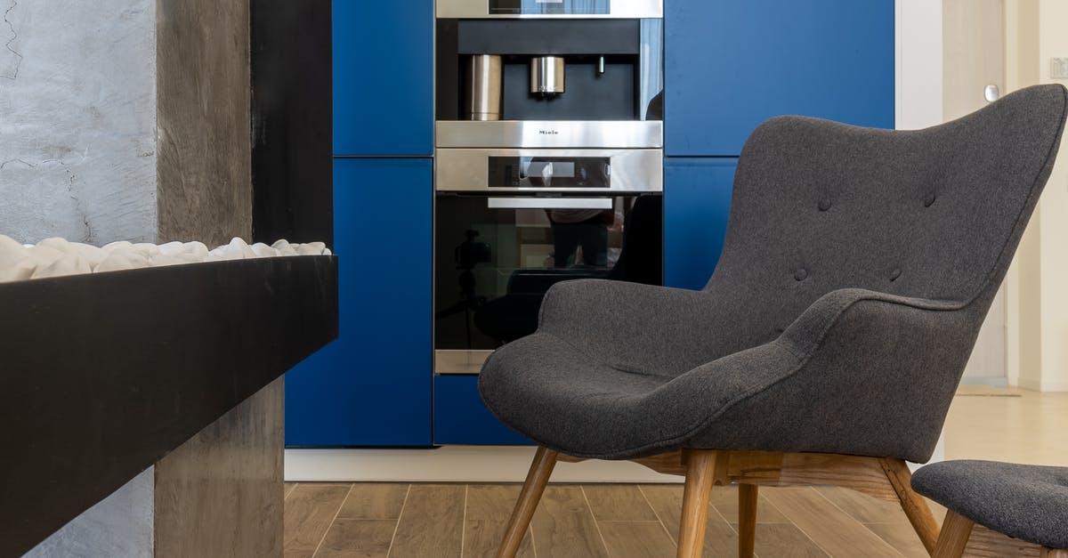 Stainless steel vs ceramic Enamel microwave ovens - Modern armchairs placed near built in ice maker with microwave and oven in stylish kitchen Stainless steel vs ceramic Enamel microwave ovens - Modern armchairs placed near built in ice maker with microwave and oven in stylish kitchen