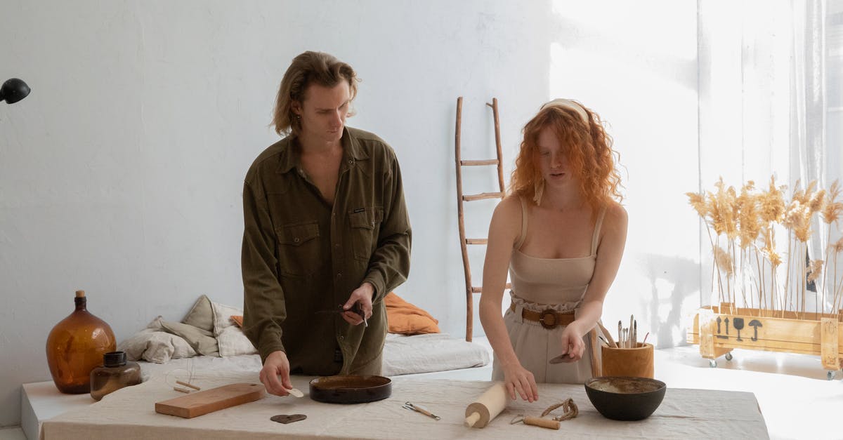 Standing Rib Roast - Young man with female partner in casual clothes preparing pottery tools at table in workroom Standing Rib Roast - Young man with female partner in casual clothes preparing pottery tools at table in workroom