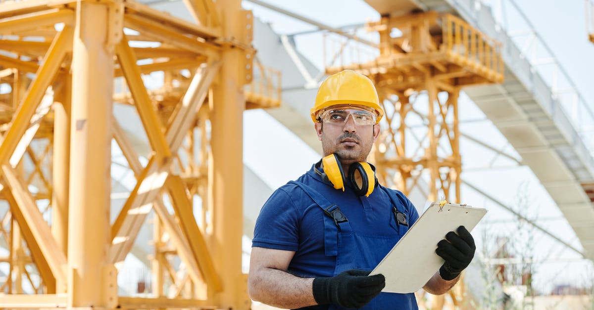 Standing rib roast and safety standards collision - Man in Blue Shirt and Yellow Hard Hat Holding White Board Standing rib roast and safety standards collision - Man in Blue Shirt and Yellow Hard Hat Holding White Board