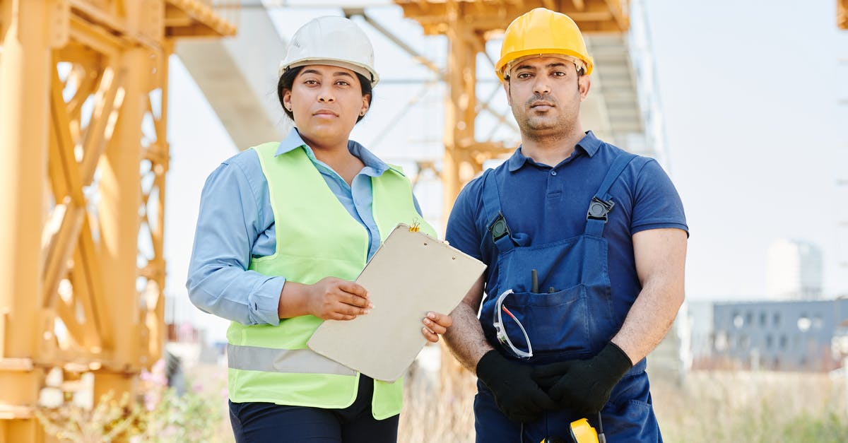 Standing rib roast and safety standards collision - Man in Blue Shirt Wearing Yellow Hard Hat Standing beside a Woman in Blue Long Sleeve Shirt Standing rib roast and safety standards collision - Man in Blue Shirt Wearing Yellow Hard Hat Standing beside a Woman in Blue Long Sleeve Shirt