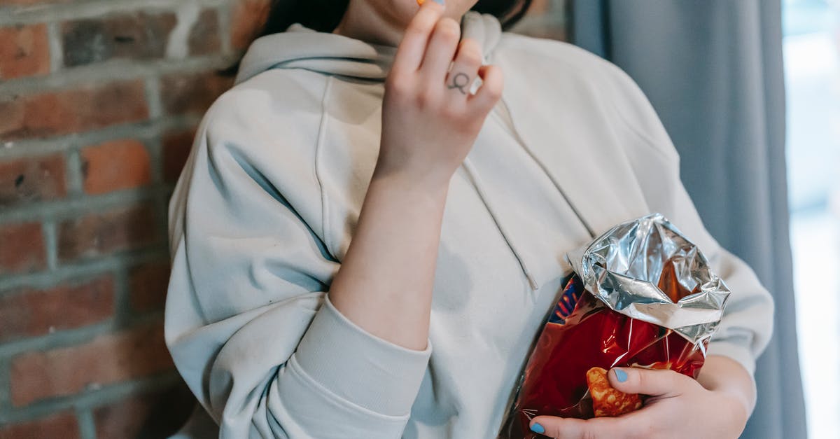 Starch Content of Dehydrated Potatoes - Crop plump female in casual hoodie enjoying crispy baked breads and licking lips against brick wall Starch Content of Dehydrated Potatoes - Crop plump female in casual hoodie enjoying crispy baked breads and licking lips against brick wall