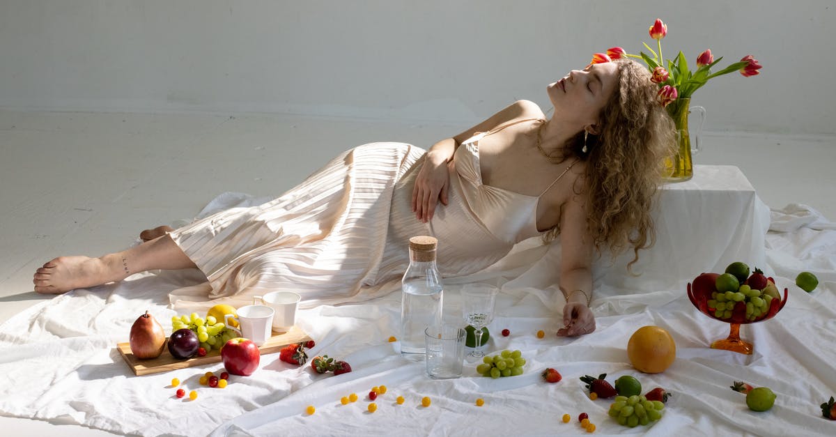 Starter with water, flour, grated apple - Peaceful young elegant woman lying on floor near fruits scattered on white cloth Starter with water, flour, grated apple - Peaceful young elegant woman lying on floor near fruits scattered on white cloth