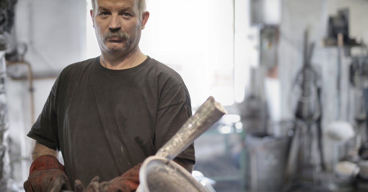 Steaks look light brown aren't charing - Male metallurgist working with metal in workshop Steaks look light brown aren't charing - Male metallurgist working with metal in workshop