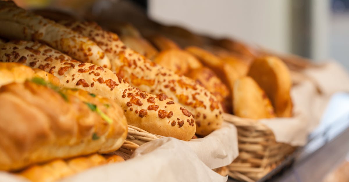 Storing hard crusted bread - Tasty assorted fresh baked baguettes and buns with bread placed in wicker baskets on shelf in light store