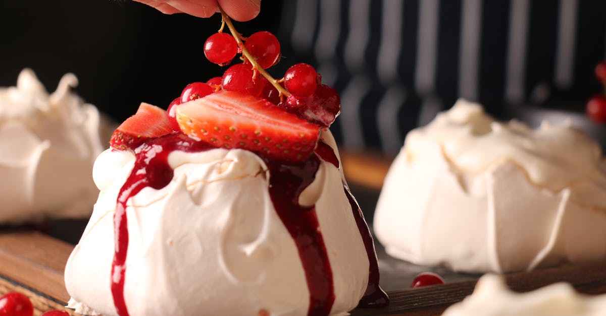 Strawberry sauce fermented in fridge? - Crop anonymous cook decorating tasty crunchy meringue cake with ripe strawberry slices and sprig of colorful red currants on top of sweet red sauce in restaurant kitchen Strawberry sauce fermented in fridge? - Crop anonymous cook decorating tasty crunchy meringue cake with ripe strawberry slices and sprig of colorful red currants on top of sweet red sauce in restaurant kitchen