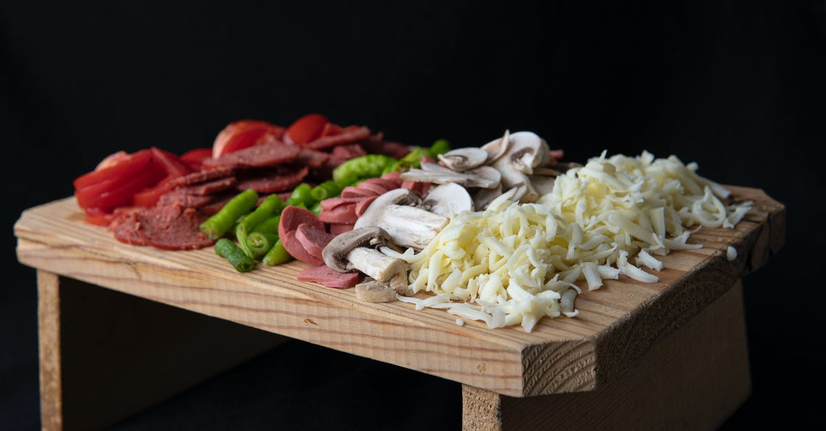 Substitute Cayenne Pepper for Black Pepper - Soft focus of sliced tomatoes and hot peppers placed on chopping board with sausages and grated cheese on black background Substitute Cayenne Pepper for Black Pepper - Soft focus of sliced tomatoes and hot peppers placed on chopping board with sausages and grated cheese on black background