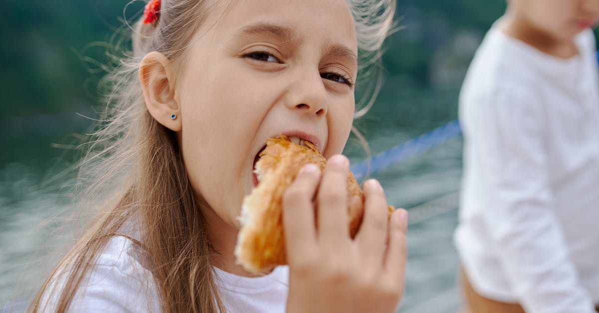 Substitute for sugar/golden syrup as binding agent in breakfast bars for kids - Happy little girl eating tasty croissant