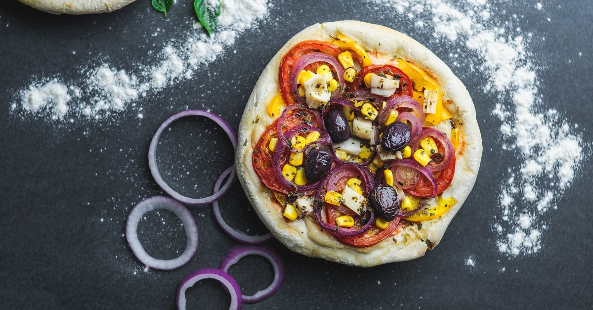 Substitute nixtamalized corn flour for corn meal + corn starch - Flat lay of pizza with sliced onion and tomatoes covered with corns on table with flour and green leaves Substitute nixtamalized corn flour for corn meal + corn starch - Flat lay of pizza with sliced onion and tomatoes covered with corns on table with flour and green leaves