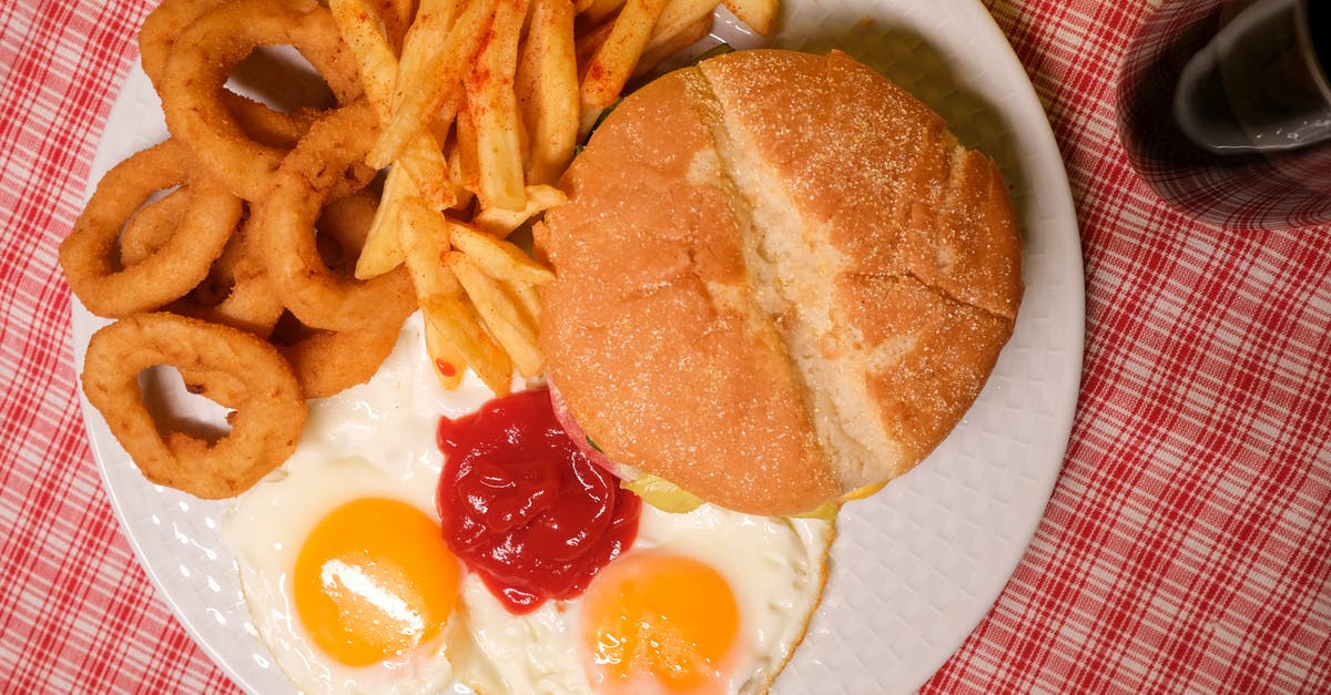 Substitution for egg to bind hamburger mince - Top view of delicious hamburger with French fires and onion rings served on plate with eggs and ketchup near glass of coke Substitution for egg to bind hamburger mince - Top view of delicious hamburger with French fires and onion rings served on plate with eggs and ketchup near glass of coke