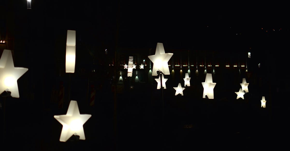 Substitution for idealmjöl - Creative star shaped garlands with glowing lamps decorating street against dark night sky Substitution for idealmjöl - Creative star shaped garlands with glowing lamps decorating street against dark night sky
