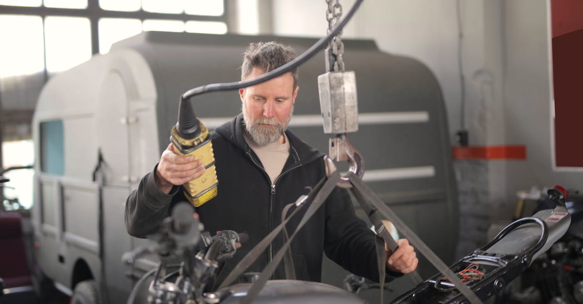 Substitution of root beer concentrate for extract - Male mechanic using hydraulic crane in garage Substitution of root beer concentrate for extract - Male mechanic using hydraulic crane in garage