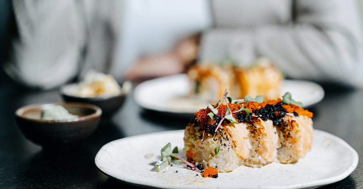 Sushi rolls opening up - Garnished Sushi Rolls on a Ceramic Plate Sushi rolls opening up - Garnished Sushi Rolls on a Ceramic Plate