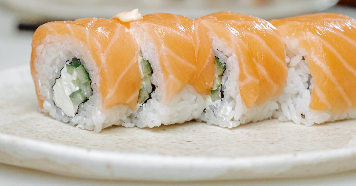 Sushi rolls opening up - Sliced Salmon on White Ceramic Plate Sushi rolls opening up - Sliced Salmon on White Ceramic Plate