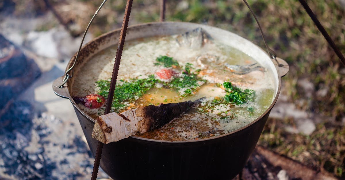 Szechuan fish soup ingredient -- what is it? - Birch firewood in ukha with aromatic broth and cut fresh herbs in cast iron pot outdoors Szechuan fish soup ingredient -- what is it? - Birch firewood in ukha with aromatic broth and cut fresh herbs in cast iron pot outdoors
