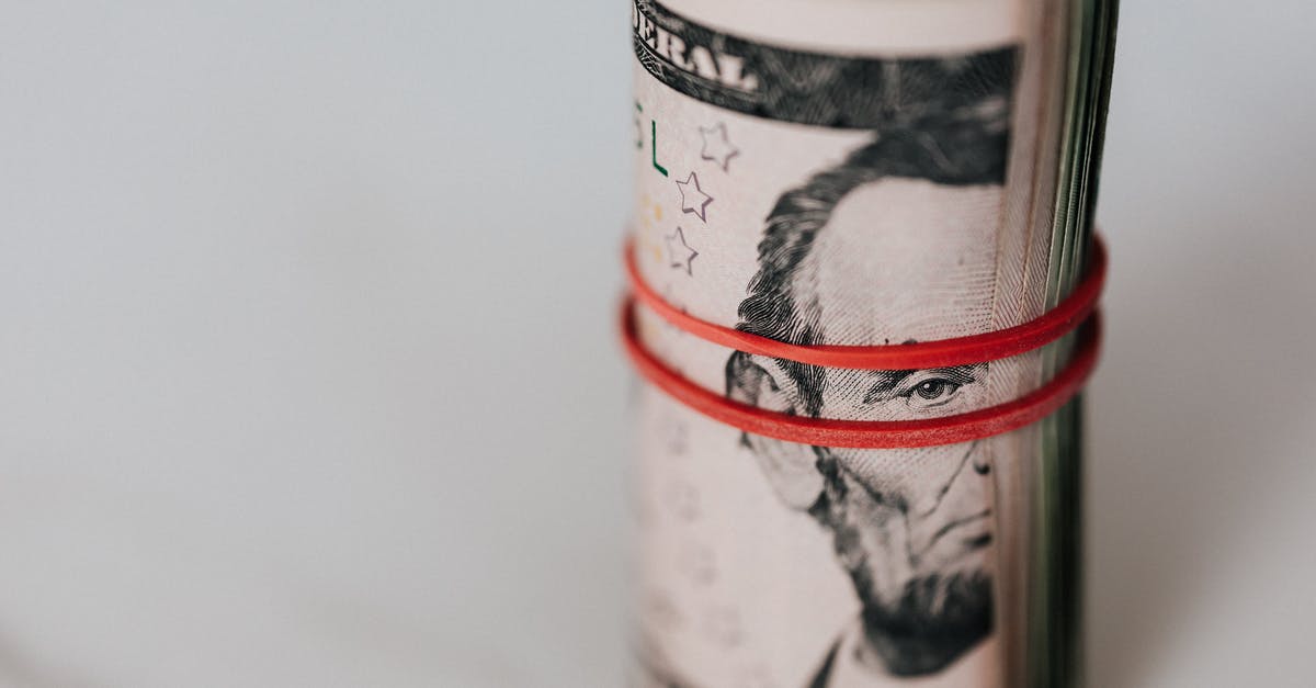 tarry deposit in wok - Roll of american dollars tightened with red band tarry deposit in wok - Roll of american dollars tightened with red band