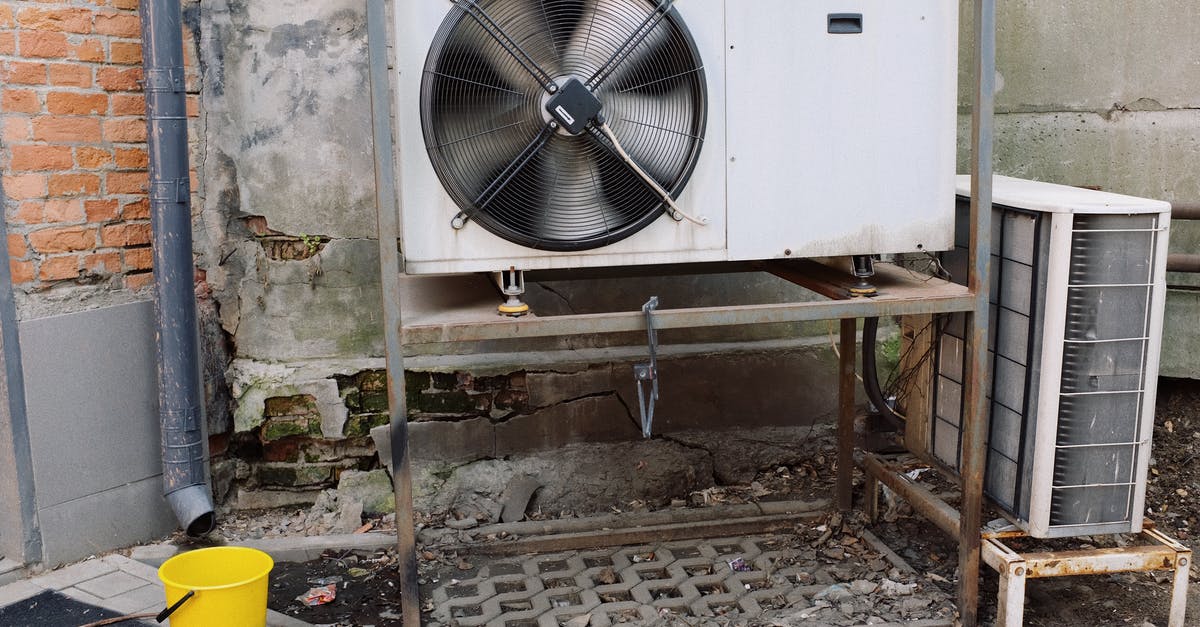 Temperature of Electric Fan Ovens - Air conditioner unit near wall of modern building on street Temperature of Electric Fan Ovens - Air conditioner unit near wall of modern building on street